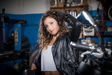 Fototapeta na wymiar beautiful girl sitting on a motorcycle in the garage. slight blur 