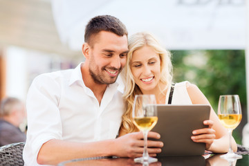happy couple with tablet pc at restaurant lounge