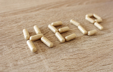 Word help created by medicine pills on the table