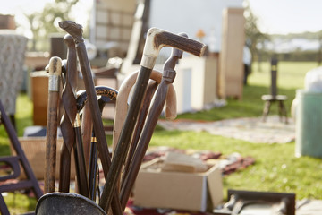 Selection of wooden canes and walking sticks for sale at an open air flea market stall.