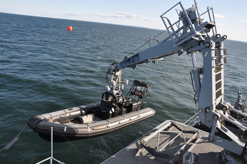 Kran mit Schnellboot auf einem Kriegsschiff