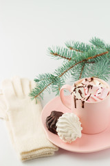 Hot chocolate with marshmallows and women's gloves on a white ba