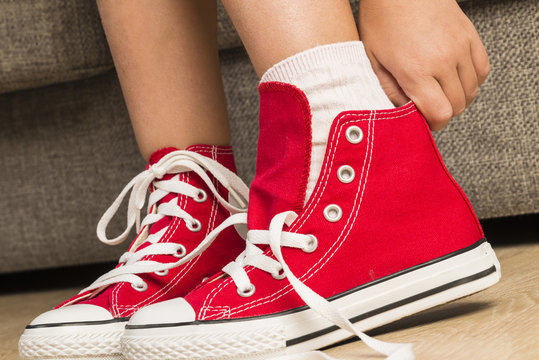 Girl wearing a pair of red sneakers