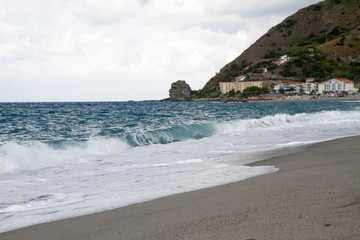 the waves breaking on the deserted beach, the background blue sk