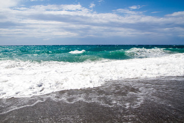 the waves breaking on the deserted beach, the background blue sk