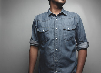 Portrait of a  young man in a blue jeans shirt on the background