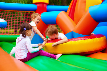 Fototapeta na wymiar excited kids having fun on inflatable attraction playground