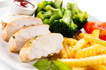 Grilled chicken fillet and vegetables on white background 