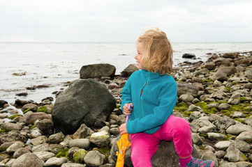 little girl on beach is looking to the sea