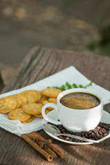 Cup of coffee on a wooden board and biscuits