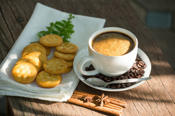 Cup of coffee on a wooden board and biscuits