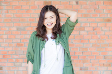 Happy asian woman with black Hair standing Against Old Brick Wal