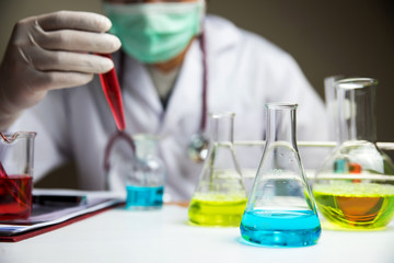 Fototapeta premium Laboratory glassware with out of focus scientist background 