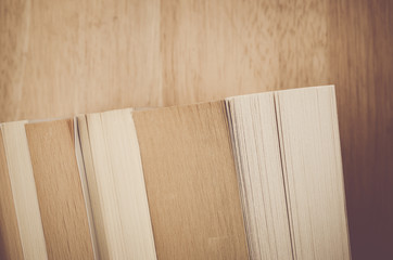 books and manuals side view close up - soft natural wood background