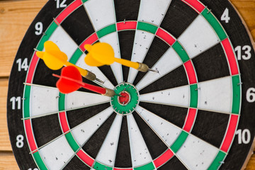 closeup red and yellow darts sticking in the target, hit the tar