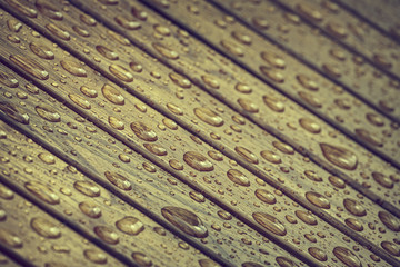 Water drops pattern on wooden surface. Tinted colors, matte filter. Shallow depth of field.