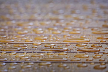 Water drops on wooden surface. Very shallow depth of field.