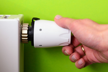 Radiator thermostat and hand - GREEN POWER energy SAVING concept