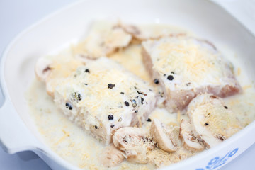 Filete de róbalo crudo marinando en molde para hornear