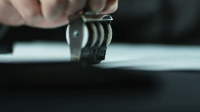 hands stamping paperwork