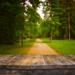 vintage wooden board table in front of dreamy autumn abstract forest landscape

