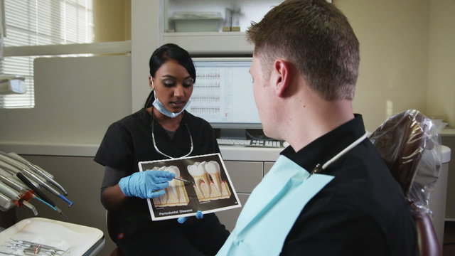 dental hygienist explaining dental care to a man