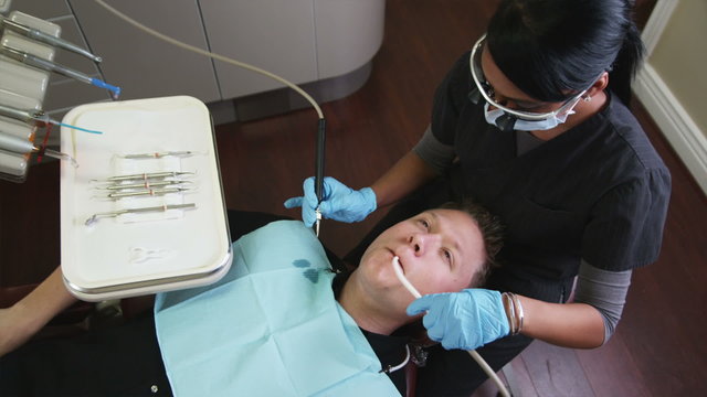 dental hygienist working on a male patient