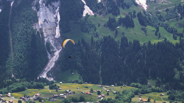 paraglider soaring above an alpine valley
