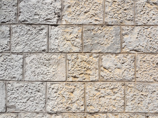 Mauer aus hellen rechteckigen Steinen als Hintergrund