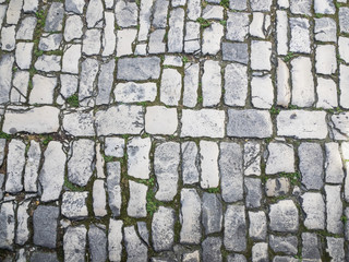 Unregelmäßiges Kopfsteinpflaster mit breiten Fugen als Hintergrund