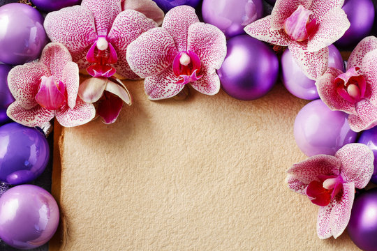 Pink orchid flowers and violet christmas balls around vintage sh