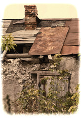 the ruins of an old barn with a lock on the door, with a hole in
