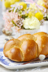 Fototapeta na wymiar Easter bun and beautiful decorations with spring flowers in the