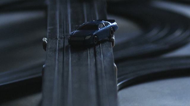 CU View of electric slot cars on racing track.