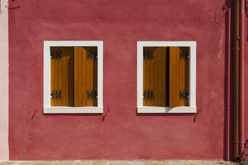 Obraz na płótnie Canvas Red wall of Burano Island with two windows, Venice, Italy