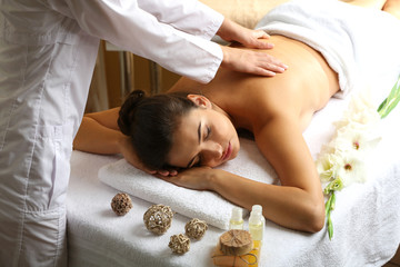 Obraz na płótnie Canvas Young woman on massage table in beauty spa salon