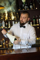 Portrait of handsome bartender with champagne bottle