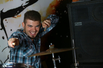 Fototapeta na wymiar Excited drummer on bright background
