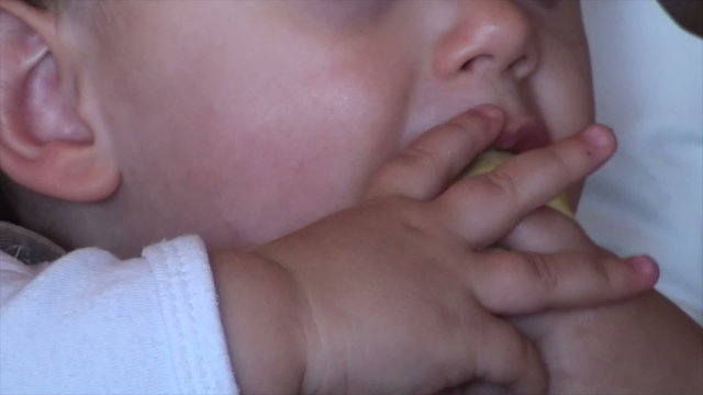 Baby eating a orange closeup