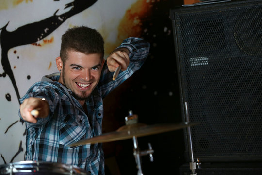 Excited drummer on bright background