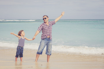 Father and son playing on the beach at the day time.