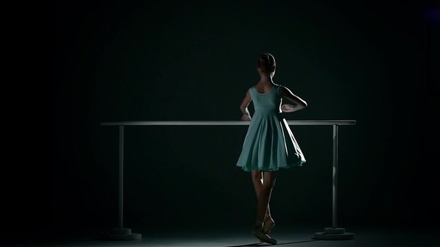 ballerina in a pretty blue dress on a dark background