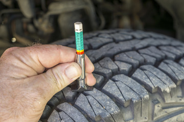 Using A Tread Wear Gauge On A Truck Tire