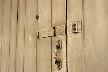 old wooden door with lock, handle, and eye hole.
