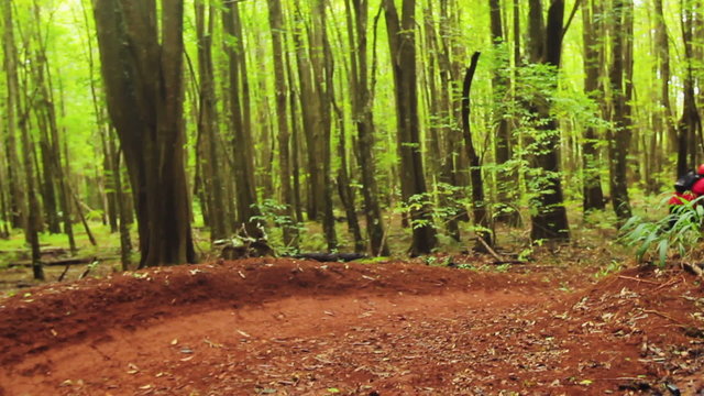 Intense Mountain Biking Follow Cam Shot Around Steep Dirt Berm Going Fast. Outdoor Active Lifestyle In The Forest.