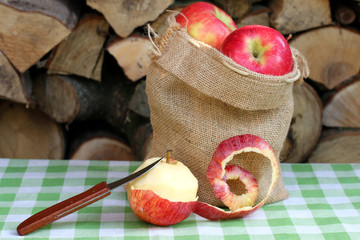 Äpfel in Jutesack, ein abgeschälter mit Messer davor