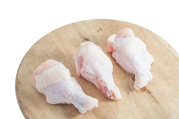 raw chicken legs on wooden cutting boards on white background