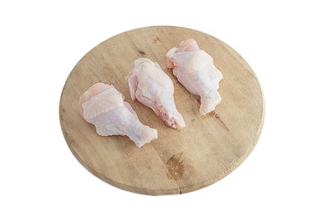 raw chicken legs on wooden cutting boards on white background