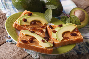 Healthy sandwich with peanut butter, avocados and raisins. horizontal
