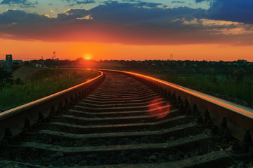 Fototapeta premium low red sun on sunset over railway